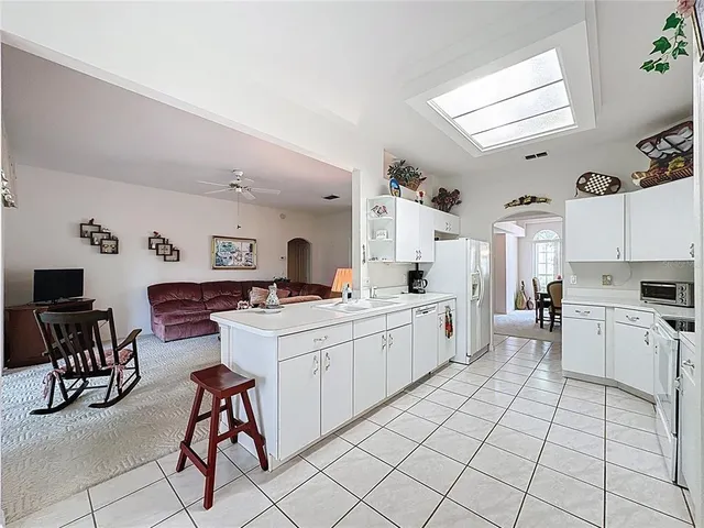 a kitchen with white cabinets a sink dishwasher and a stove with wooden floor