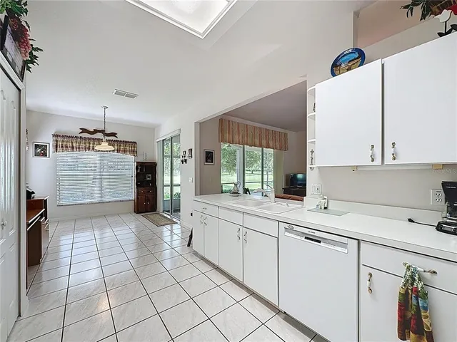 a bathroom with a granite countertop tub a sink and a large mirror next to a window