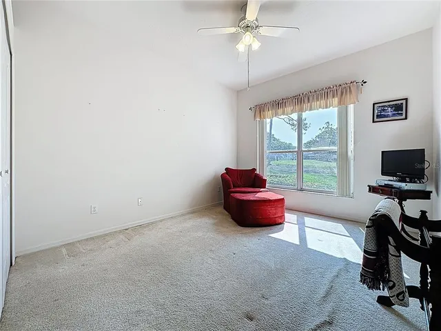 a living room with patio chairs and a floor to ceiling window