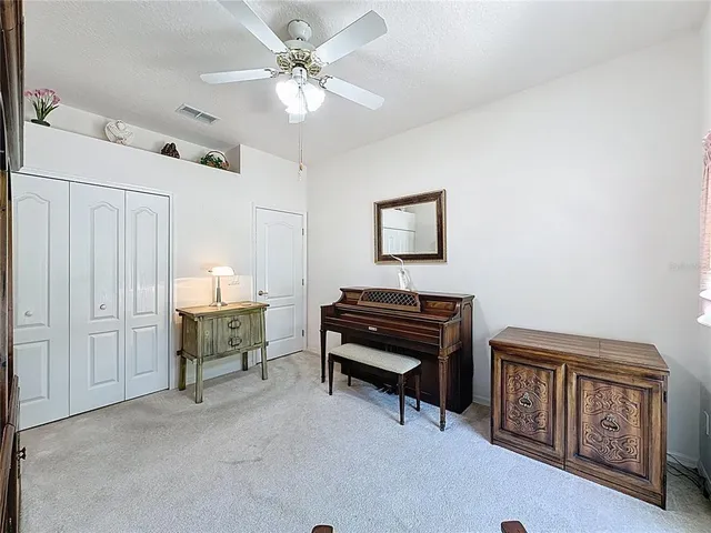 a view of a house with a yard and palm trees