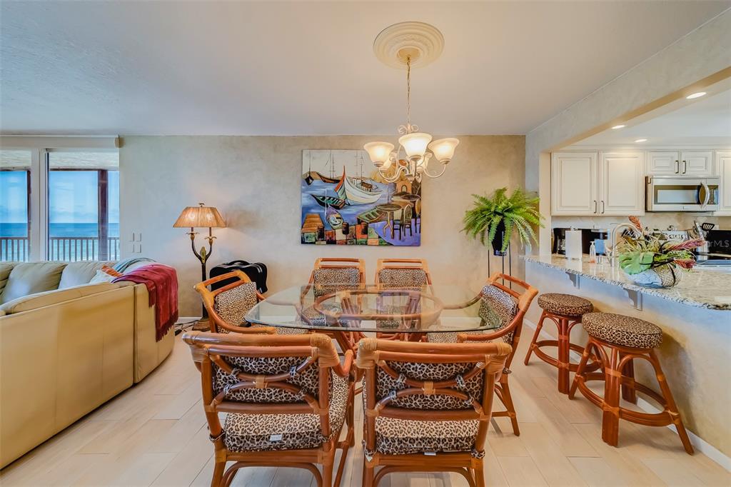 17580 Gulf Boulevard, Unit 412 Redington Shores, FL 33708 - Photo 16 of 67 a view of a dining room and livingroom with furniture wooden floor a chandelier