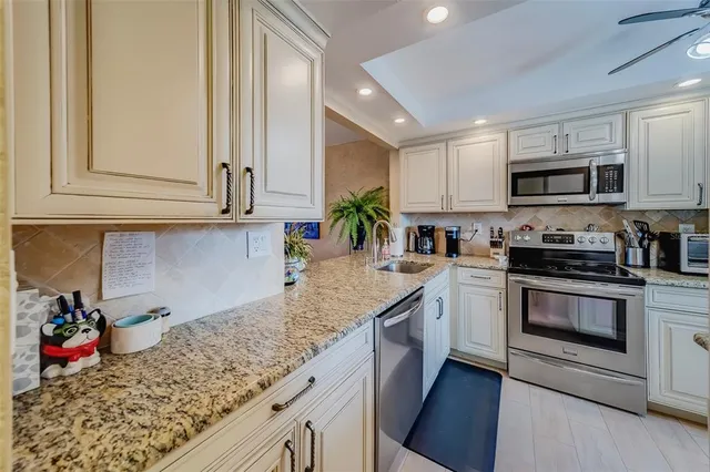 a kitchen with white cabinets and white appliances