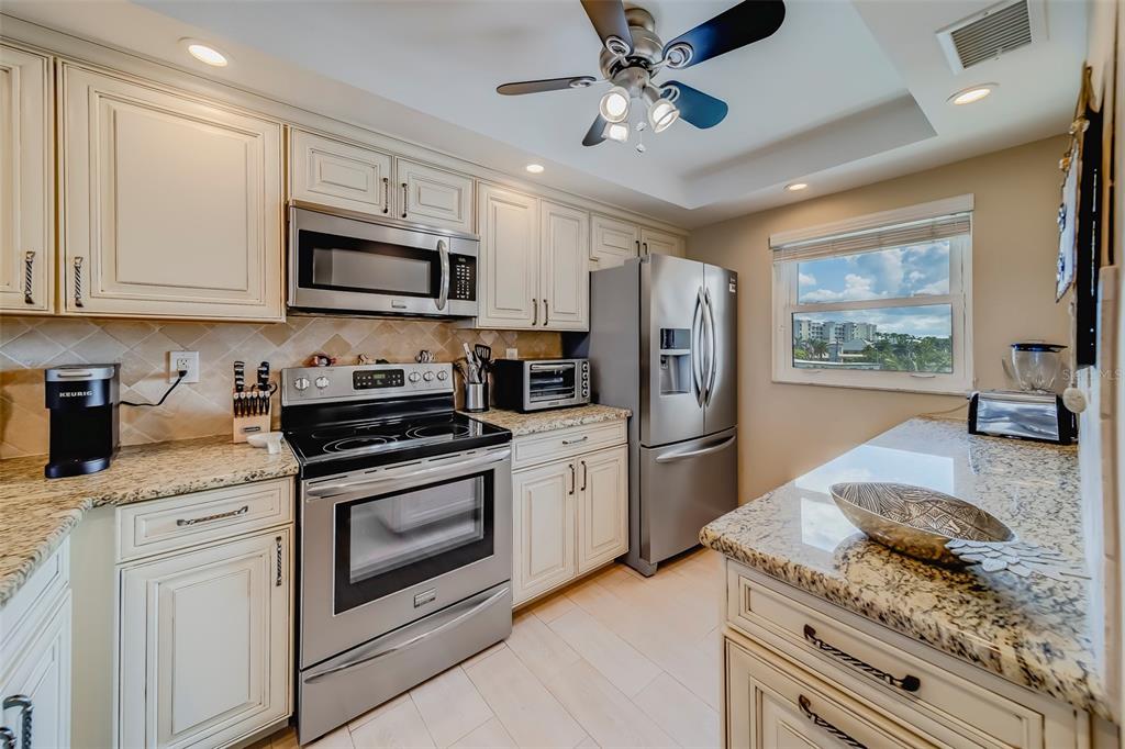 17580 Gulf Boulevard, Unit 412 Redington Shores, FL 33708 - Photo 22 of 67 a kitchen with stainless steel appliances granite countertop a stove a refrigerator and a sink