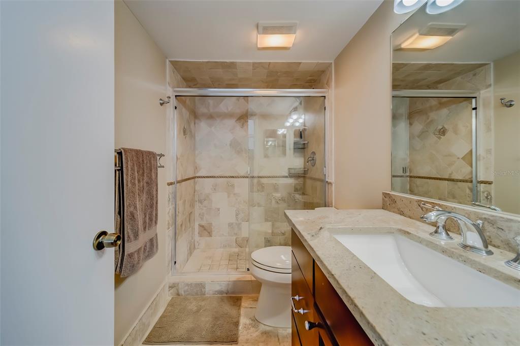 17580 Gulf Boulevard, Unit 412 Redington Shores, FL 33708 - Photo 31 of 67 a bathroom with a granite countertop sink toilet and shower