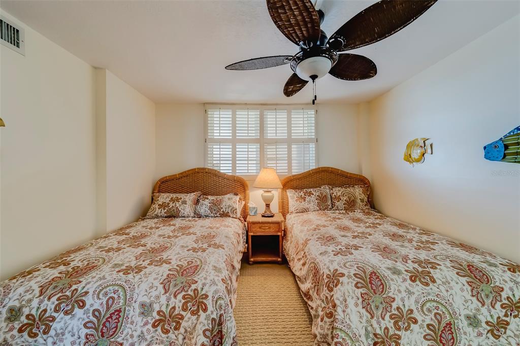 17580 Gulf Boulevard, Unit 412 Redington Shores, FL 33708 - Photo 34 of 67 a bedroom with two large bed and a chandelier