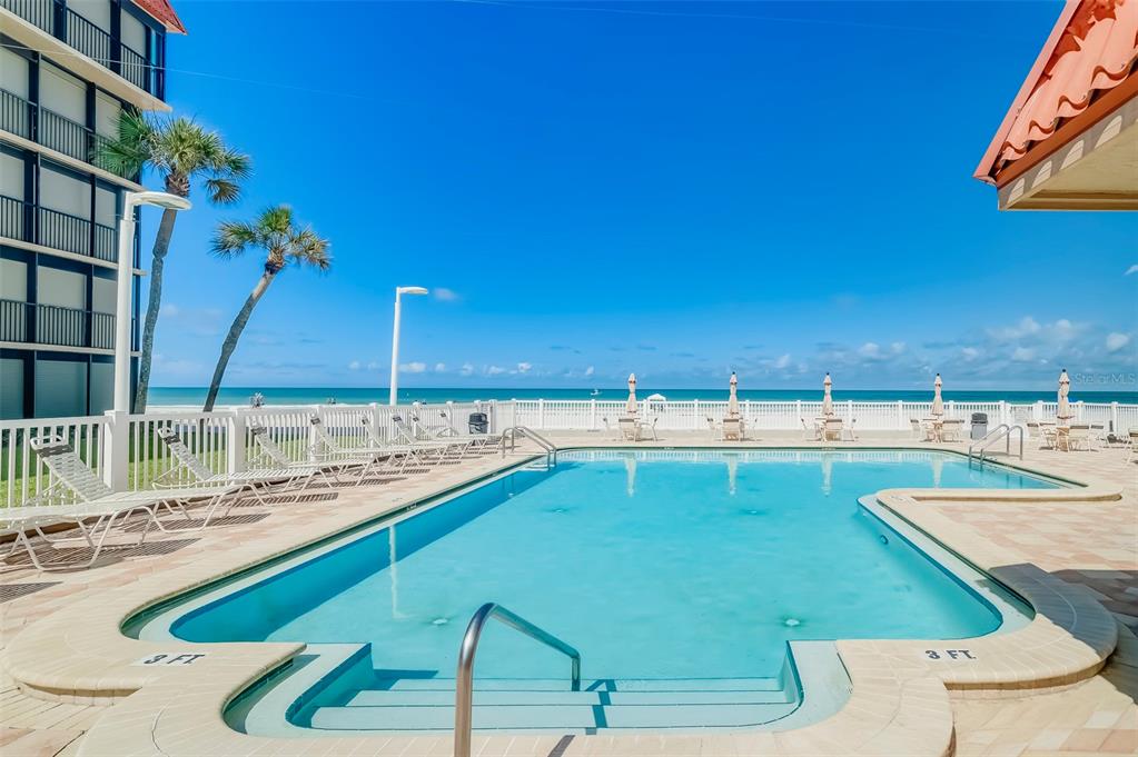 17580 Gulf Boulevard, Unit 412 Redington Shores, FL 33708 - Photo 6 of 67 a view of a swimming pool with a lawn chairs