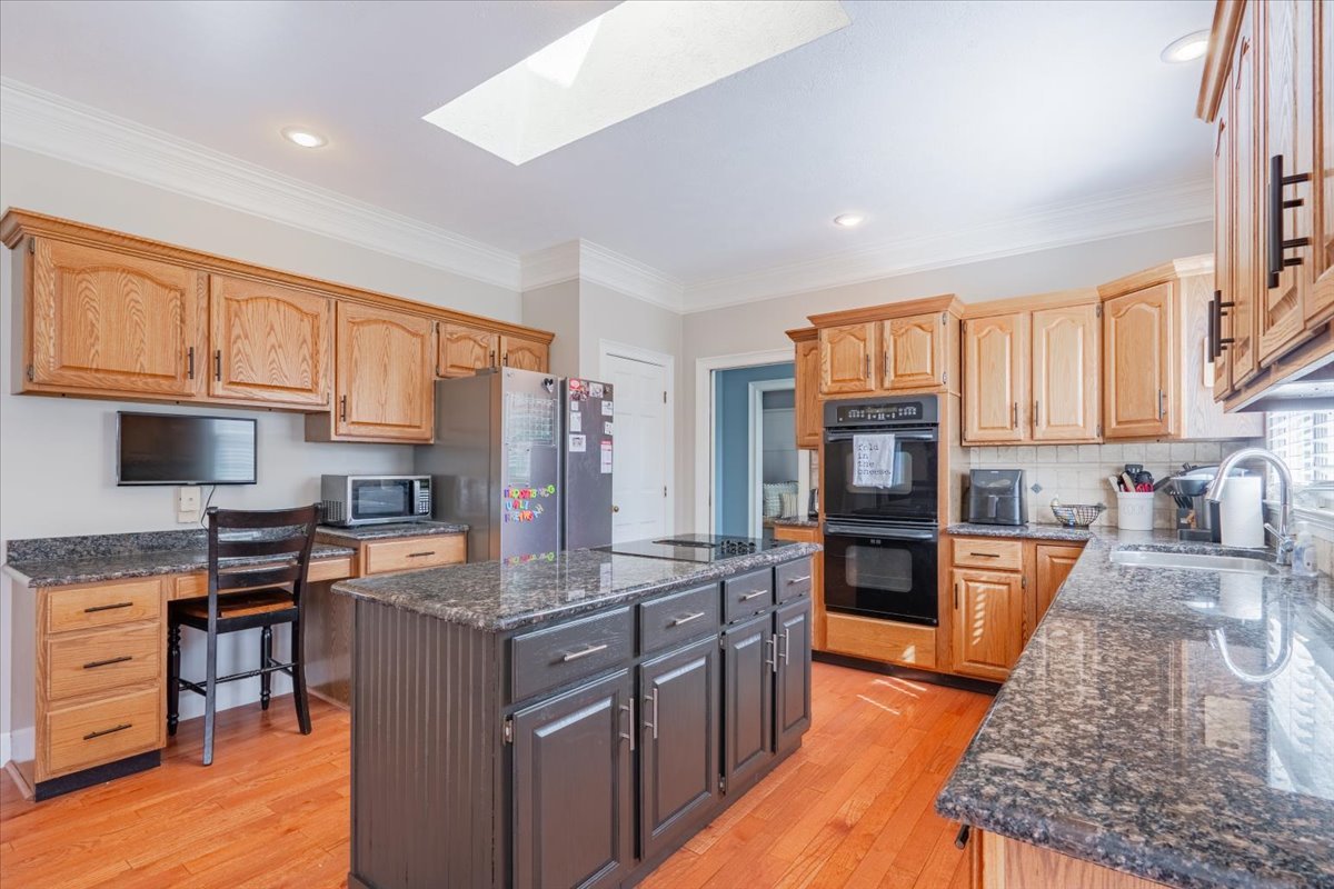 3 Downing Circle Bloomington, IL 61704 - Photo 14 of 47 a kitchen with stainless steel appliances granite countertop a stove top oven a sink dishwasher a dining table and chairs with wooden floor