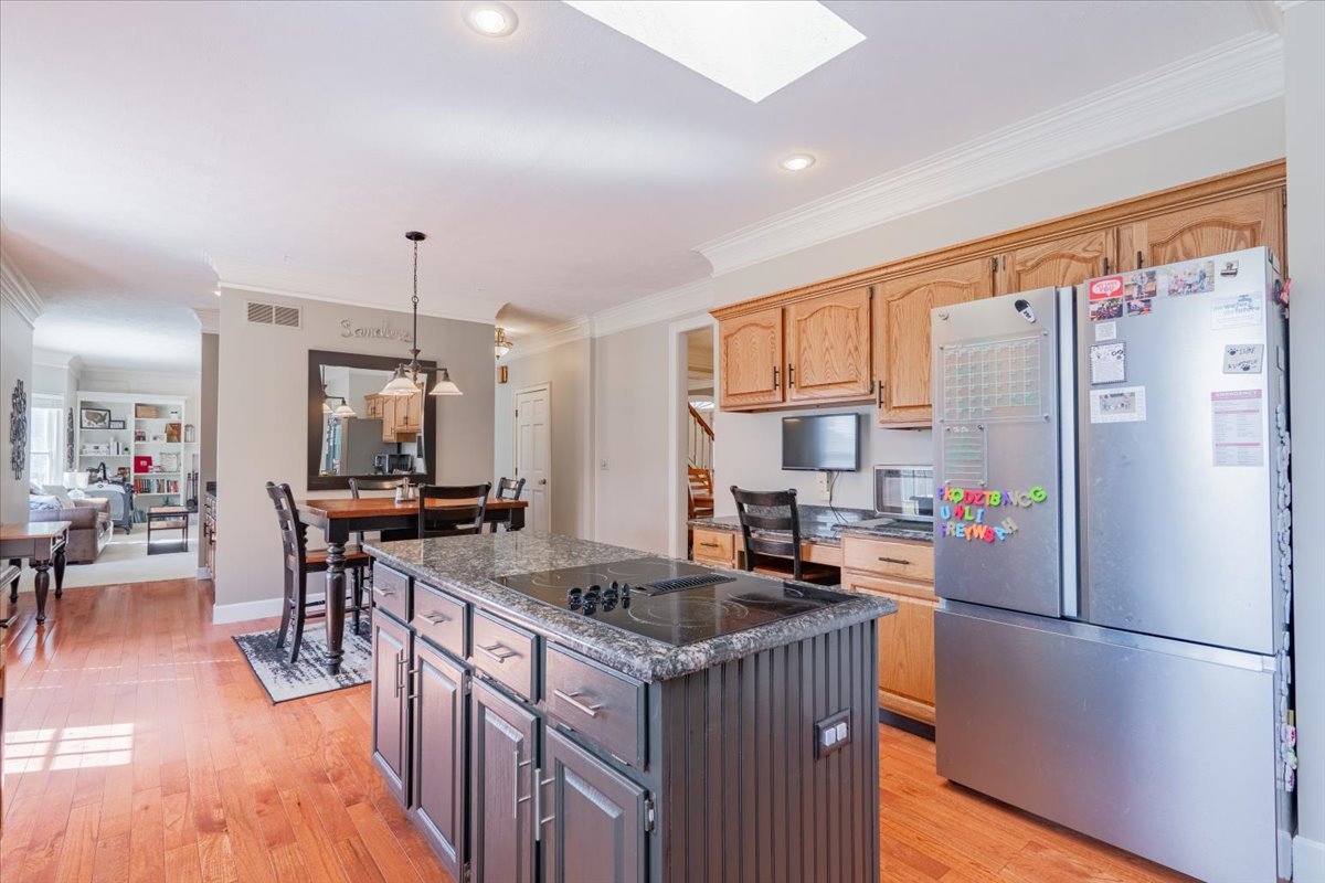 3 Downing Circle Bloomington, IL 61704 - Photo 15 of 47 a kitchen with granite countertop a refrigerator a stove a sink a dining table and chairs with wooden floor