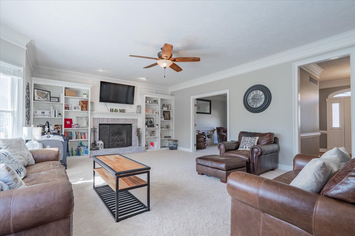3 Downing Circle Bloomington, IL 61704 - Photo 7 of 47 a living room with furniture a fireplace and a flat screen tv