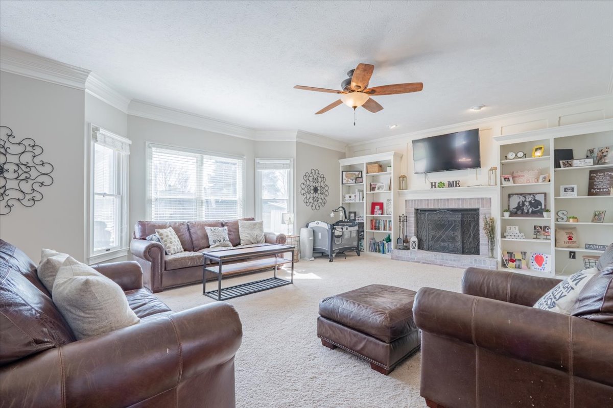 3 Downing Circle Bloomington, IL 61704 - Photo 8 of 47 a living room with furniture a fireplace and a flat screen tv