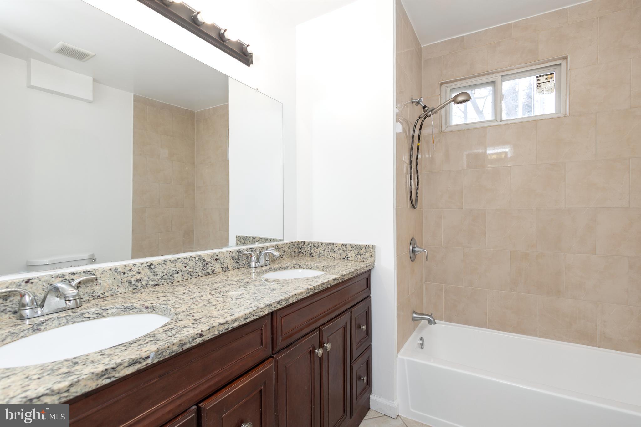 1911 17th Street Southeast Washington, DC 20020 - Photo 15 of 44 a bathroom with a granite countertop bathtub sink vanity and mirror