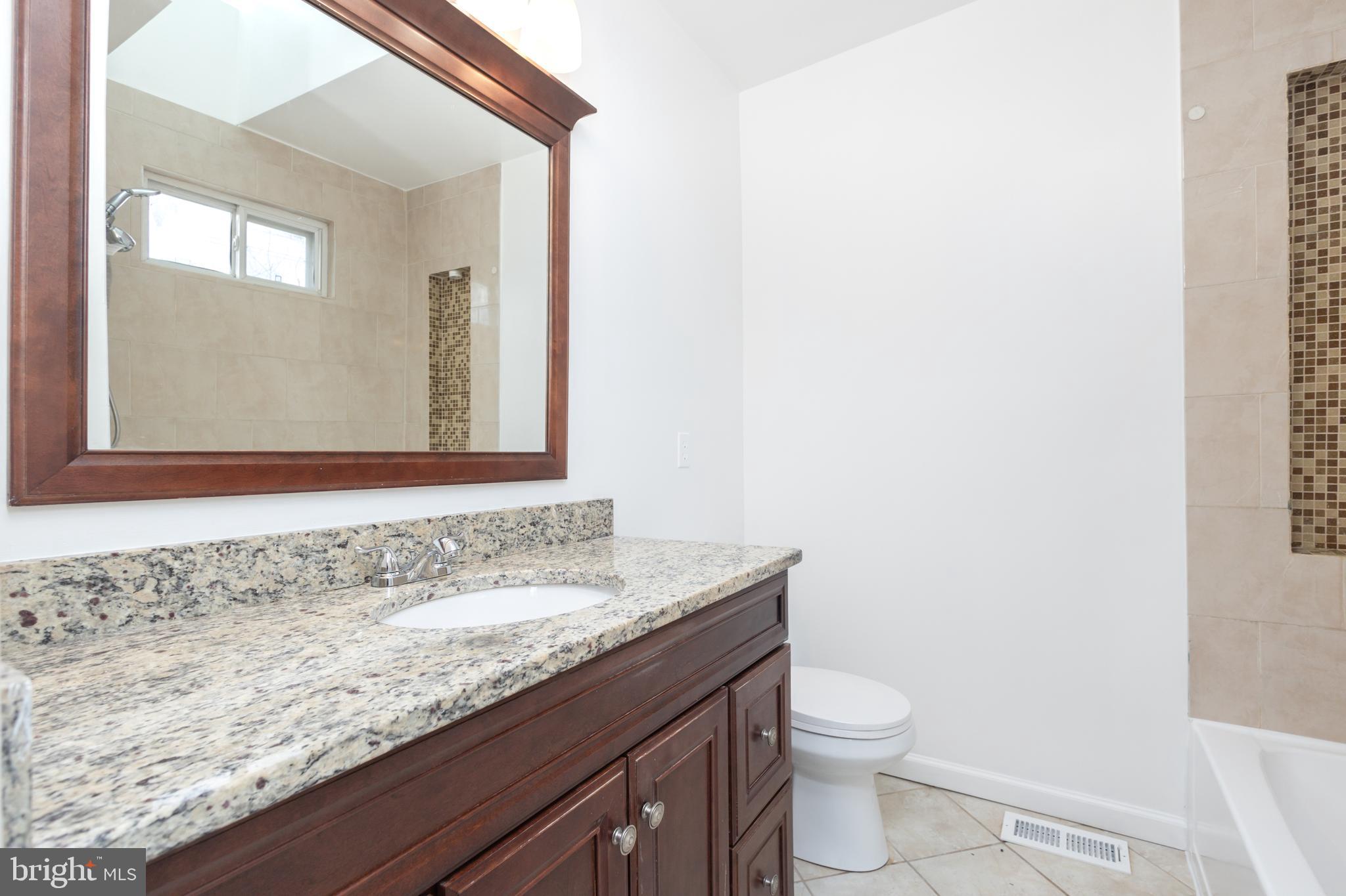 1911 17th Street Southeast Washington, DC 20020 - Photo 18 of 44 a bathroom with a granite countertop sink and a toilet