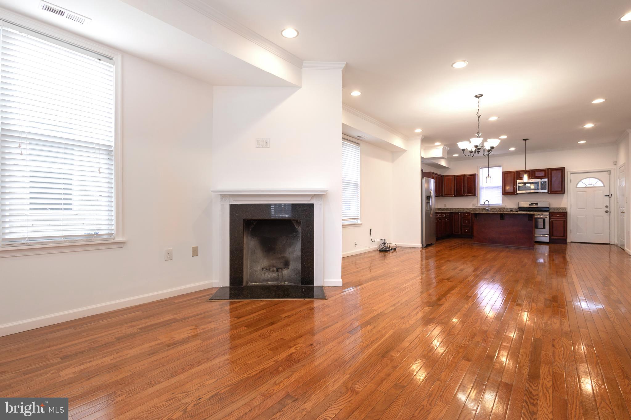 1911 17th Street Southeast Washington, DC 20020 - Photo 2 of 44 an empty room with a fireplace and kitchen view