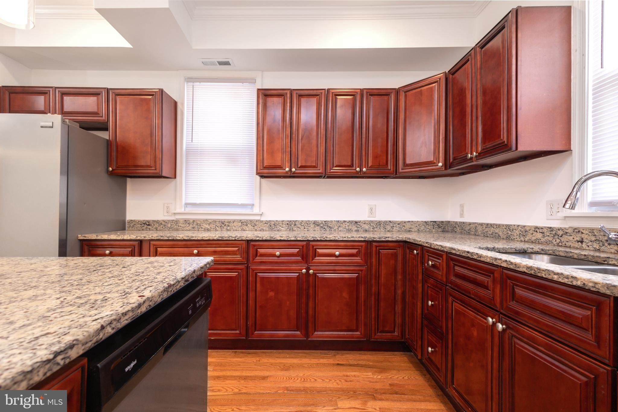 1911 17th Street Southeast Washington, DC 20020 - Photo 6 of 44 a kitchen with stainless steel appliances granite countertop wooden cabinets a stove top oven a sink and dishwasher