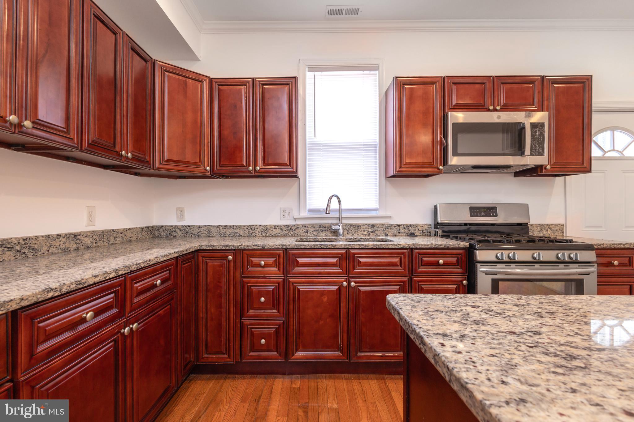 1911 17th Street Southeast Washington, DC 20020 - Photo 7 of 44 a kitchen with stainless steel appliances granite countertop a stove microwave and sink