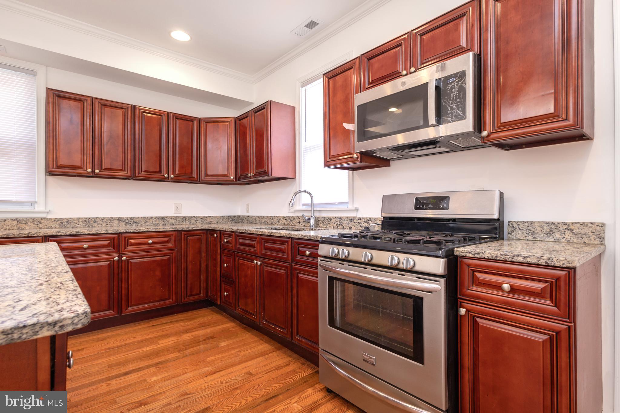 1911 17th Street Southeast Washington, DC 20020 - Photo 8 of 44 a kitchen with stainless steel appliances granite countertop wooden cabinets stove top oven and granite counter top