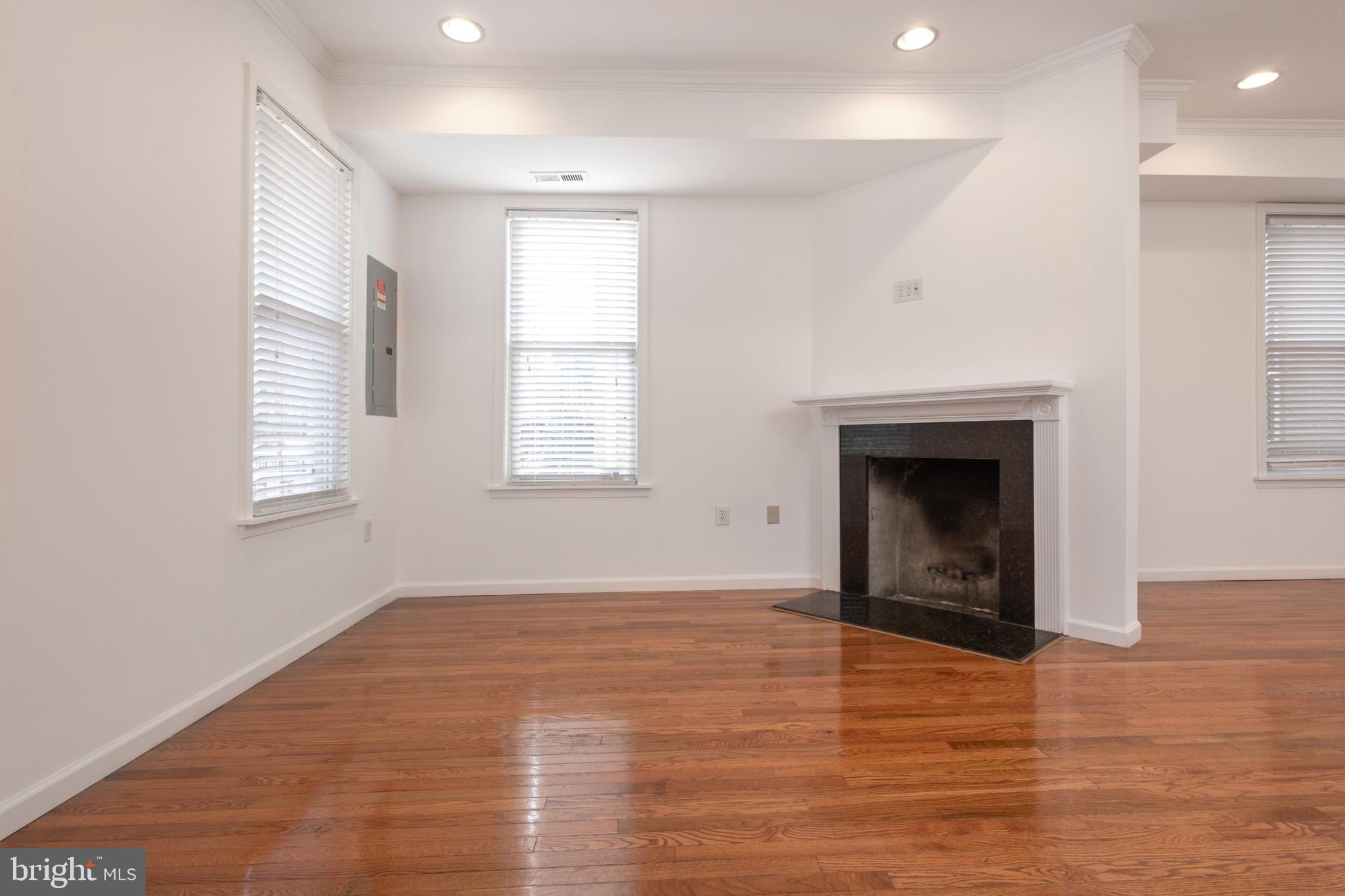 1911 17th Street Southeast Washington, DC 20020 - Photo 10 of 44 an empty room with windows and a fireplace