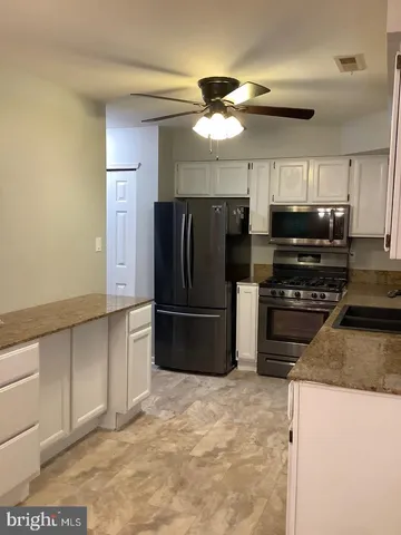 a kitchen with stainless steel appliances granite countertop a refrigerator a stove a sink a washer and dishwasher