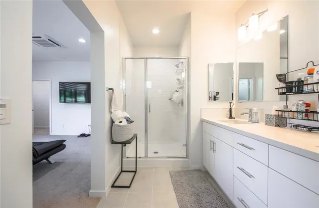a spacious bathroom with a double vanity sink a mirror and shower