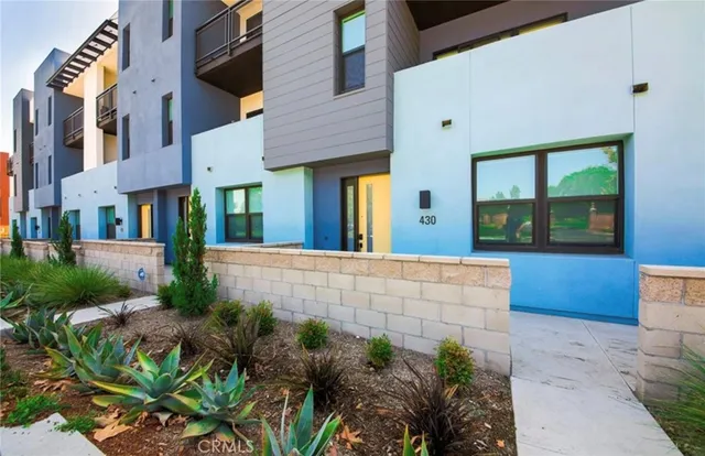 a view of brick house with potted plants