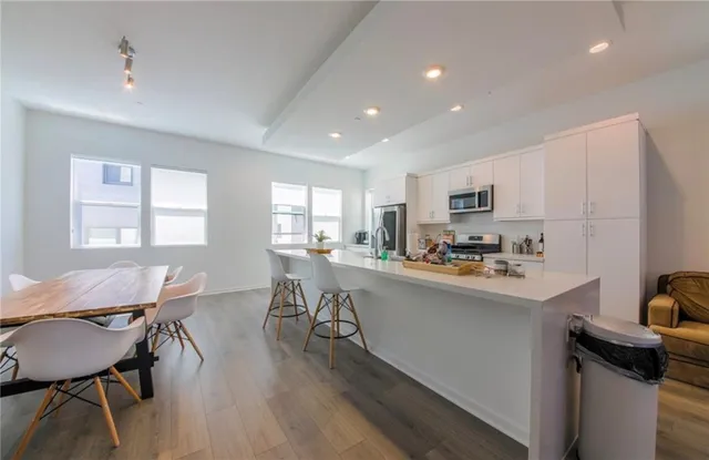 a kitchen with a dining table chairs and refrigerator