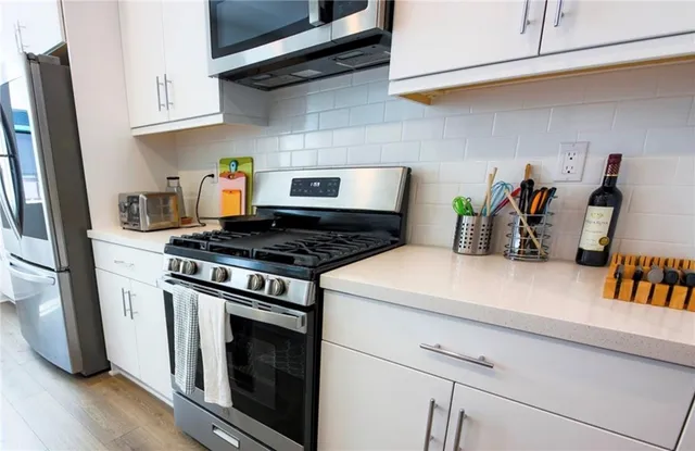 a kitchen with stainless steel appliances granite countertop a stove and a refrigerator