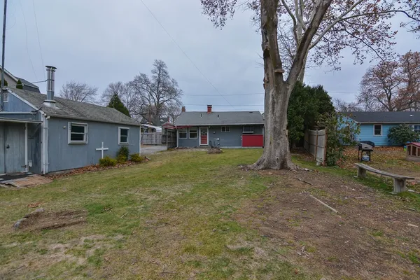 a front view of house with yard and trees in the background
