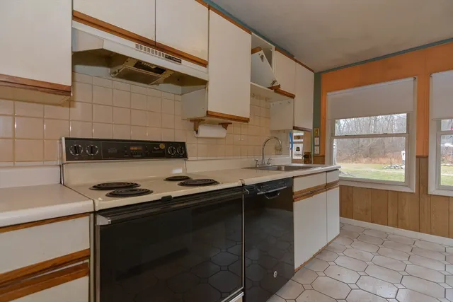 a kitchen with a sink and a stove top oven