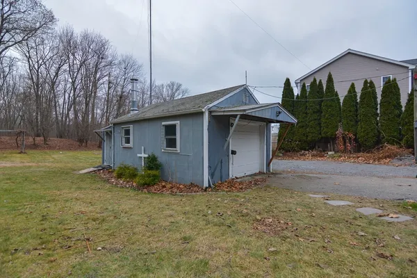 a view of a house with backyard and trees