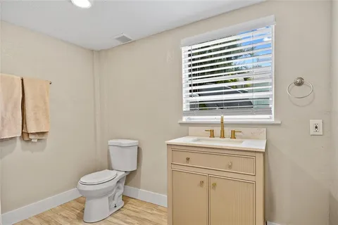 a bathroom with a toilet a sink and a window