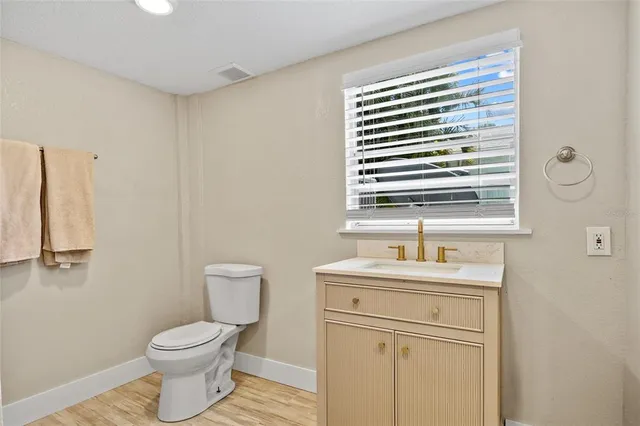a bathroom with a toilet a sink and a window
