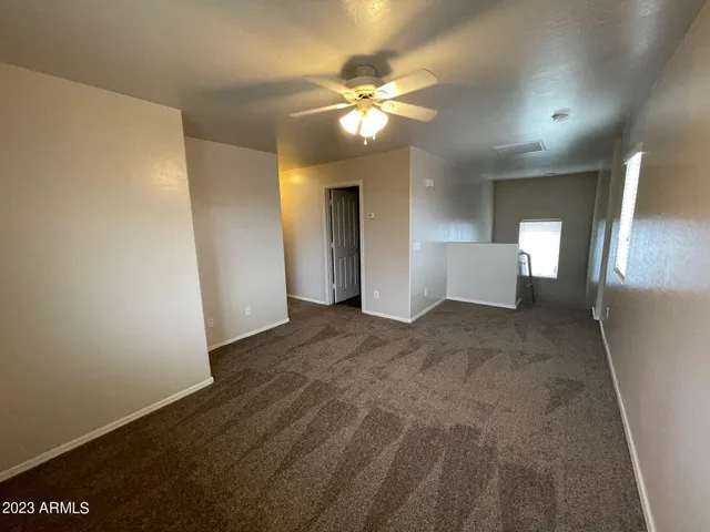 a view of a livingroom with a ceiling fan and window