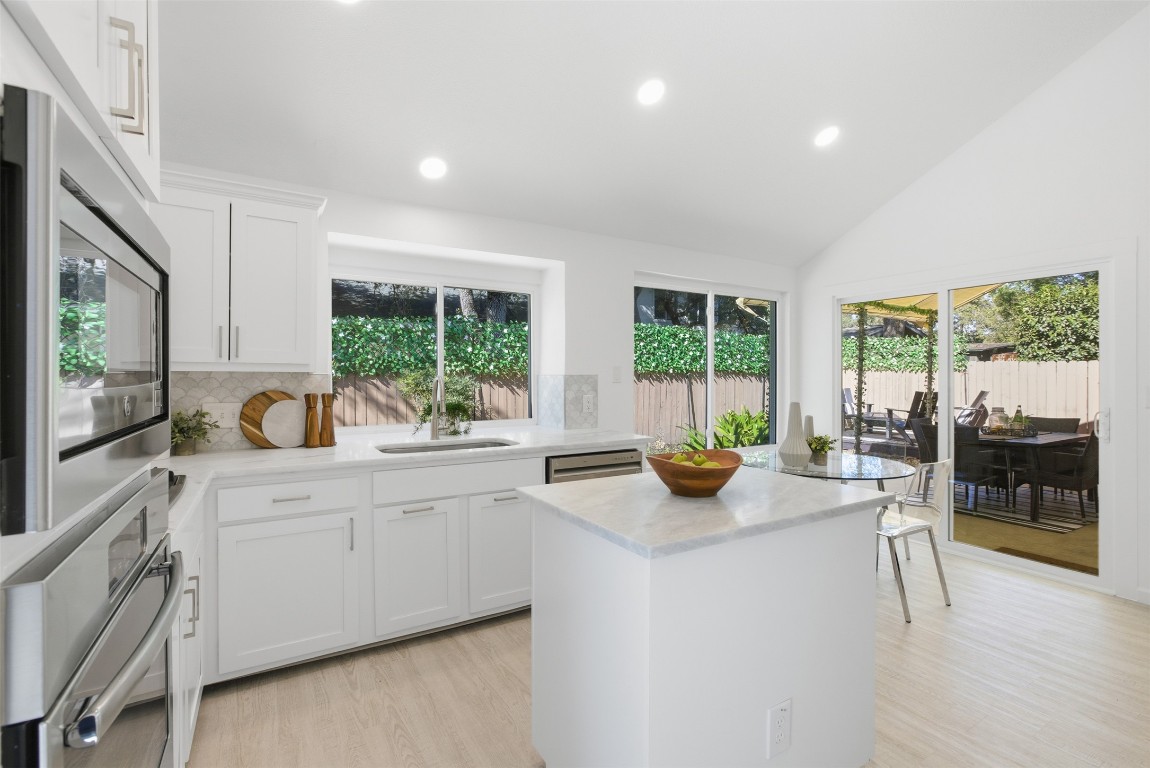 10902 Wareham Court Austin, TX 78739 - Photo 13 of 37 Kitchen featuring recessed lighting, white cabinets, appliances with stainless steel finishes, plenty of natural light, and light wood finished floors