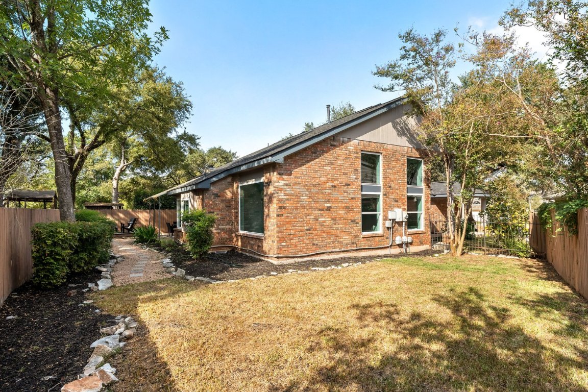 10902 Wareham Court Austin, TX 78739 - Photo 27 of 37 View of side of home featuring a fenced backyard, brick siding, and a patio