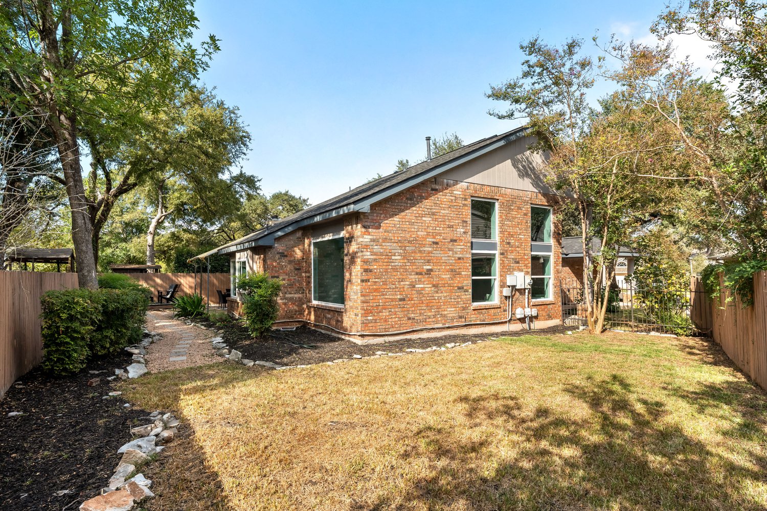 10902 Wareham Court Austin, TX 78739 - Photo 27 of 37 View of side of home featuring a fenced backyard, brick siding, and a patio