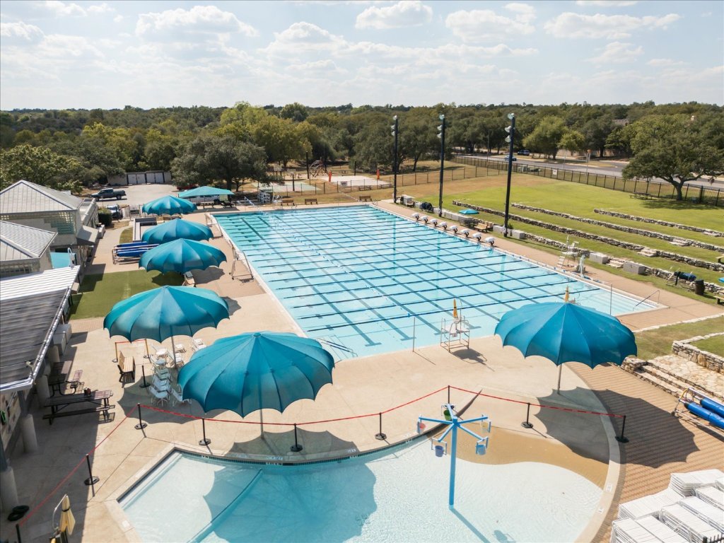 10902 Wareham Court Austin, TX 78739 - Photo 28 of 37 Community pool with view of wooded area and a patio area