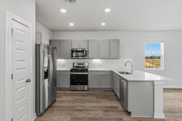 a kitchen with stainless steel appliances granite countertop a refrigerator sink and stove