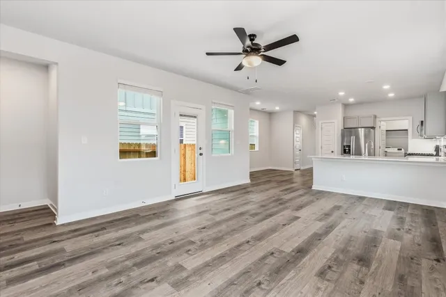 a view of a livingroom with a ceiling fan & wooden floor