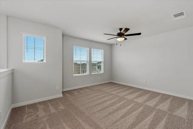 a view of a room with a ceiling fan and a window