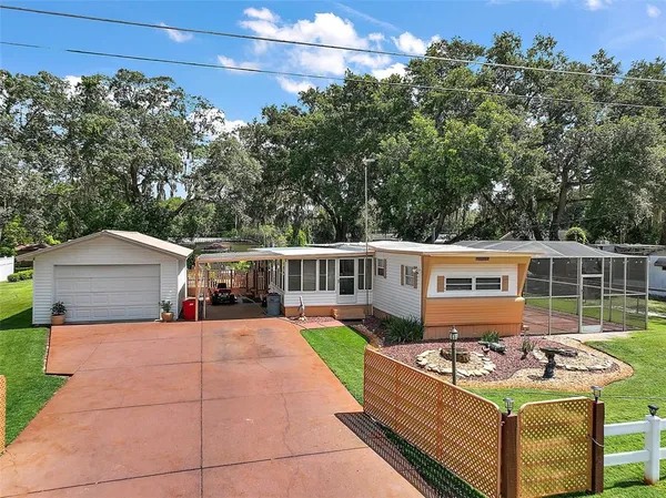 a view of a patio with couches table and chairs under an umbrella