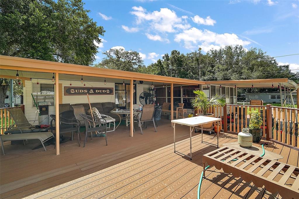 9935 Southeast 168th Place Summerfield, FL 34491 - Photo 4 of 25 a balcony with wooden floor table and chairs