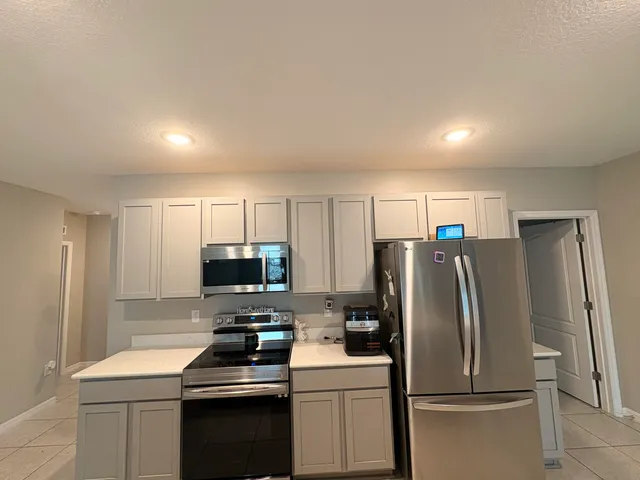 a kitchen with a refrigerator stove and microwave