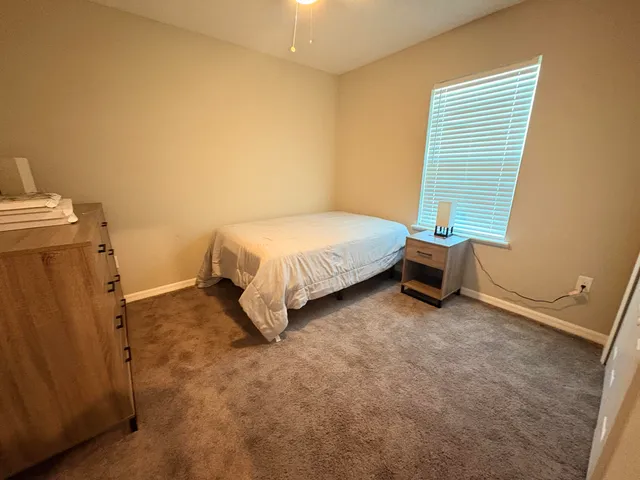 a spacious bedroom with a bed and a window