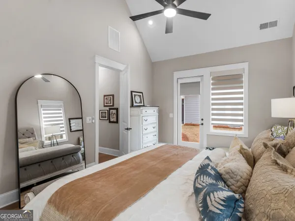 a bedroom with bed and a large mirror