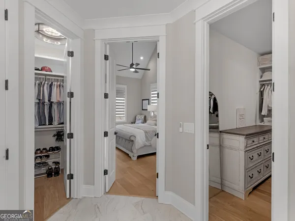 a spacious bedroom with a bed a dresser and a chandelier