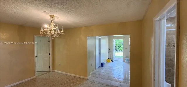 a view of a hallway with chandelier and front door