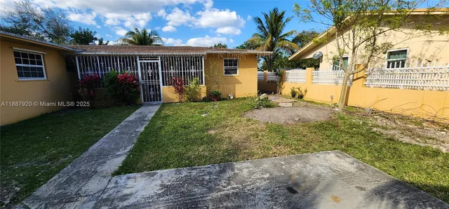 a view of backyard of house with green space