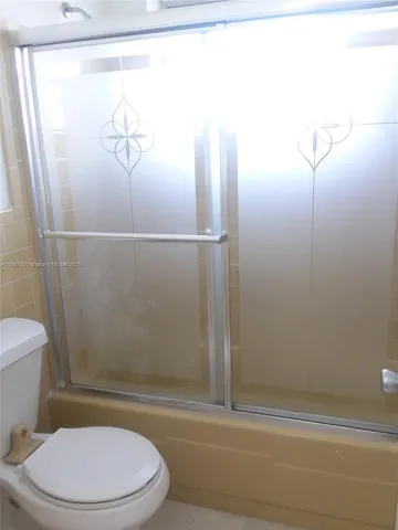 a white toilet sitting next to a bath tub