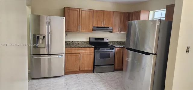 a white refrigerator freezer and a stove in a kitchen