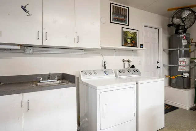 a utility room with sink dryer and washer